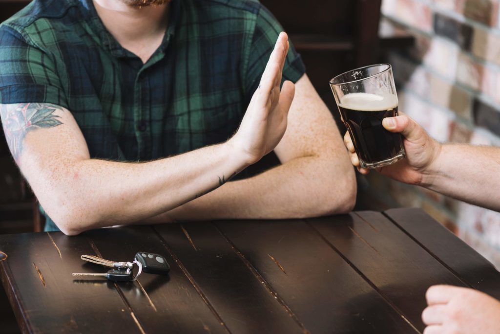 man refusing glass rum offered by his friend copia